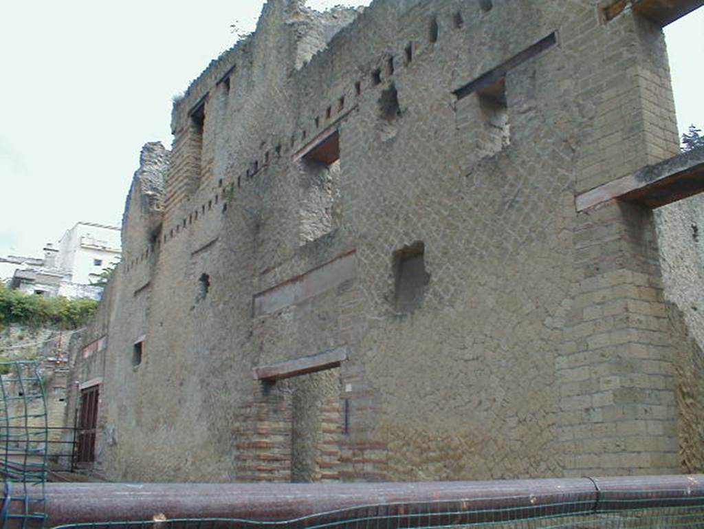 Ins. Orientalis II, 9, the bar (or wine shop) on left, 8 in centre, 7 on right.
September 2004. Looking north-east. Regarding this area with its upper floors, Wallace-Hadrill wrote that usually the rooms on the first floor followed the same plan and layout as the ground floor; generally, the first-floor rooms are associated with the shop rooms below them. The second floor is the least well preserved, though the robust construction of the Palaestra exedra seem to have kept the central section more intact. It is here that we can trace the layout of at least one flat, with several rooms around an open space. The entrance seems to have been from the wooden balcony that ran across the façade. By a bit of luck, Maiuri’s men in 1933 failed to complete their clearance of these rooms, and it was possible in 2006 to excavate the final layers of the latrine of the apartment, together with its downpipe dropping down to the sewer below. To reach the latrine from the flat, you had to go out on the balcony.
See Wallace-Hadrill, A. (2011). Herculaneum, Past and Future. London, Frances Lincoln Ltd., (p.275)